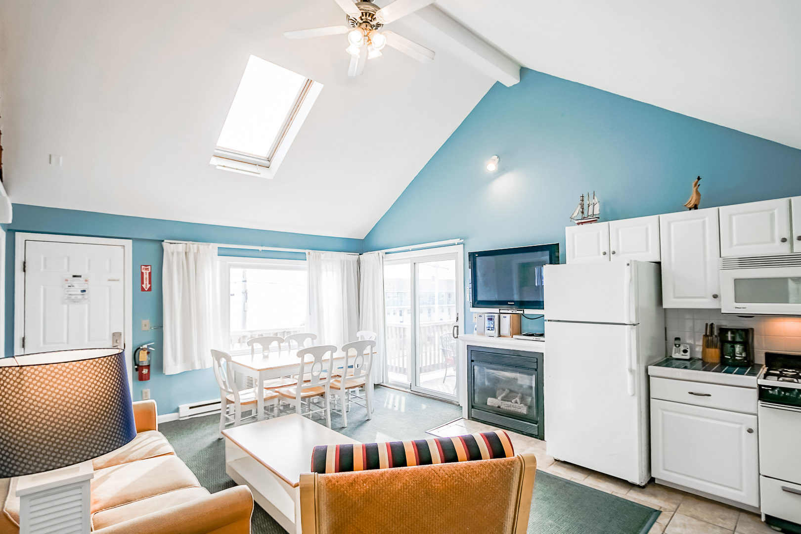 A vibrant living room area with a kitchen at VRI's Seawinds II Resort in Massachusetts.